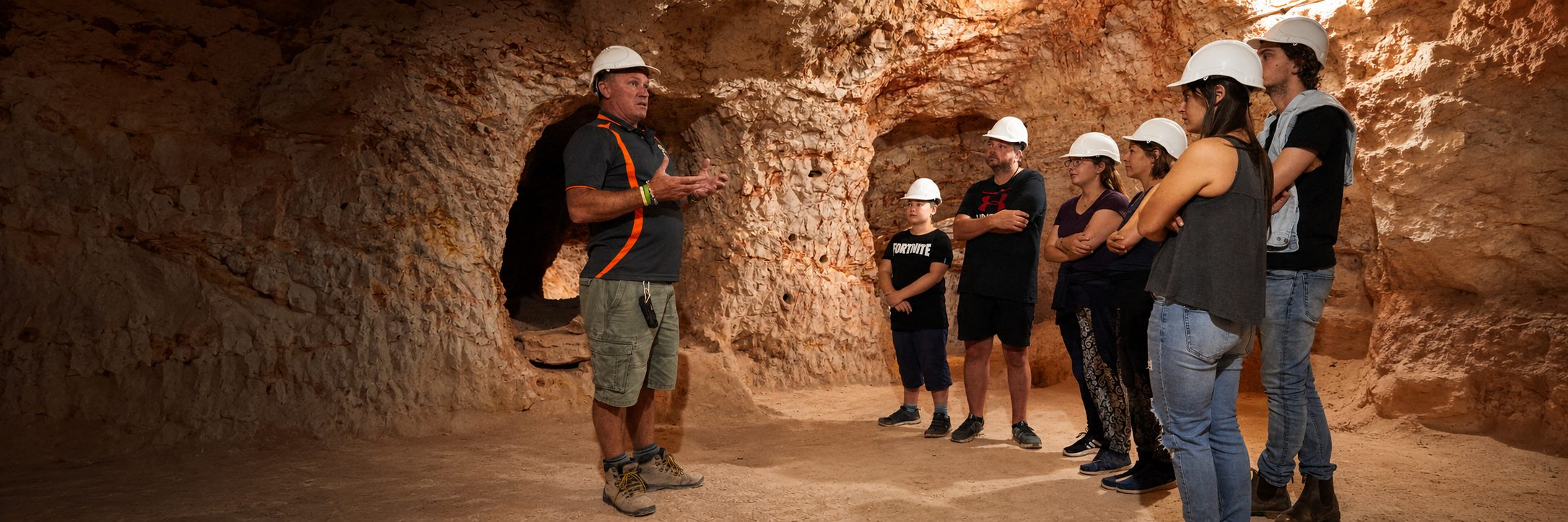 Tour guide leading visitors through an underground mine in Coober Pedy